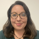 A headshot of Dr. Amanda Boczar. She has shoulder length brown hair and is wearing tortoiseshell glasses